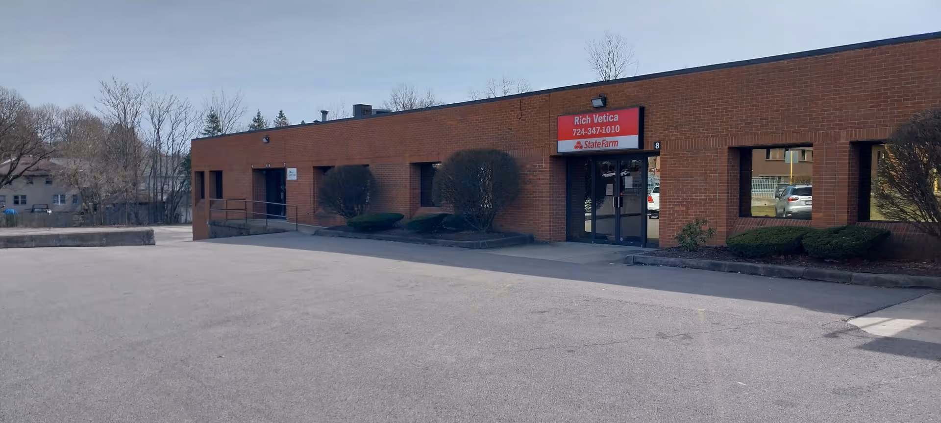 Exterior view of a brick, one-story building with a parking lot.