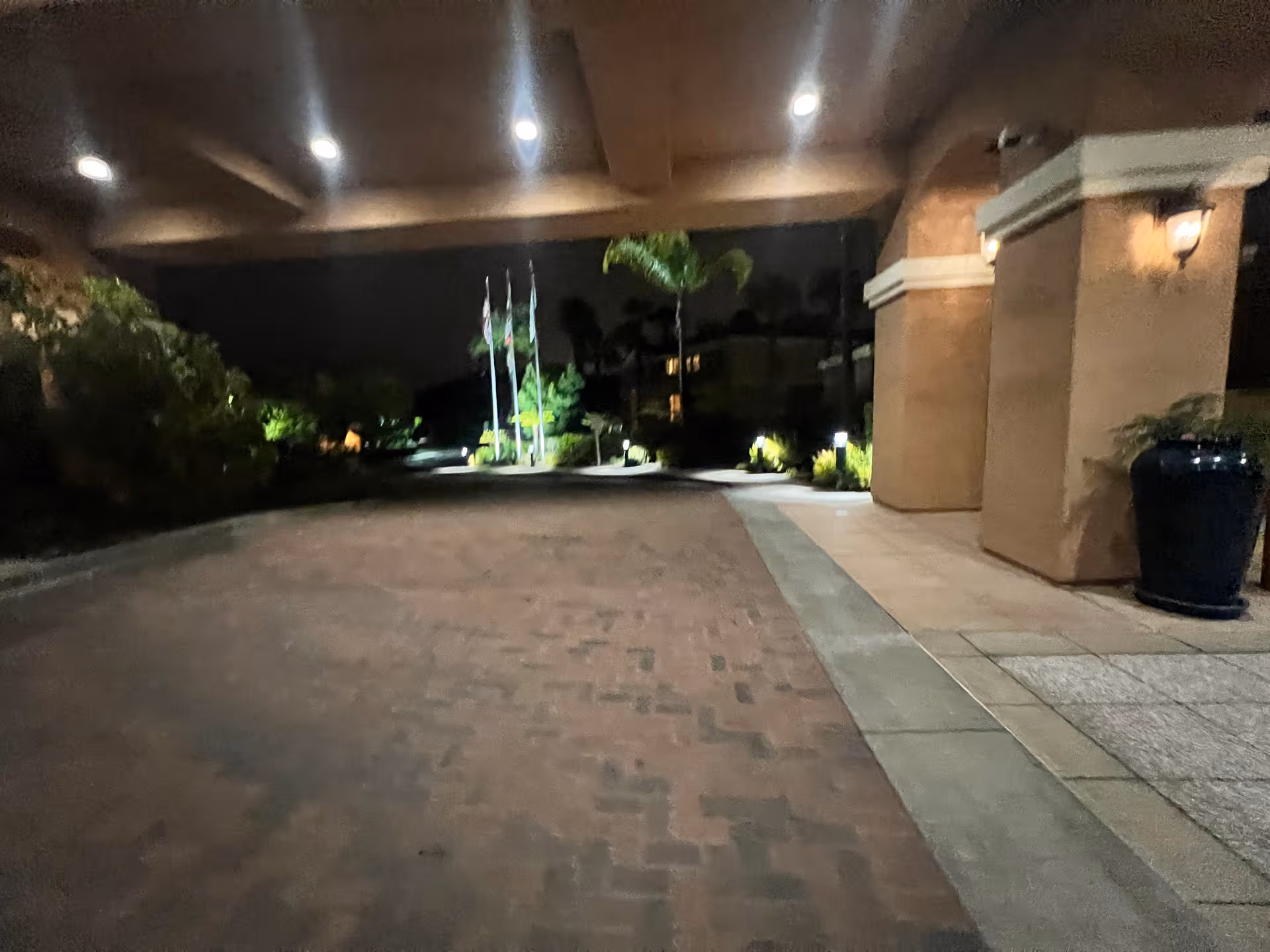 Nighttime exterior view of La Costa Glen entrance with columns and walkway.