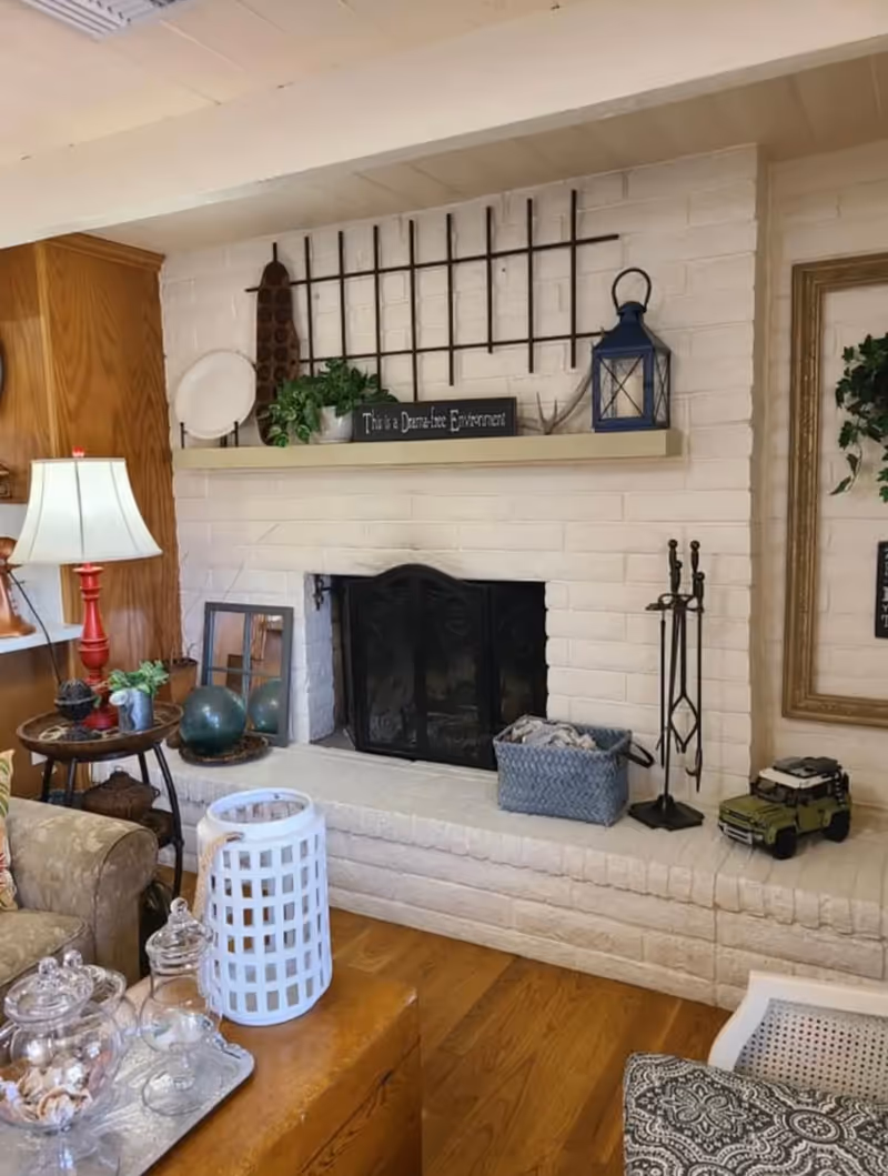 Cozy living room with white brick fireplace and mantel decor.