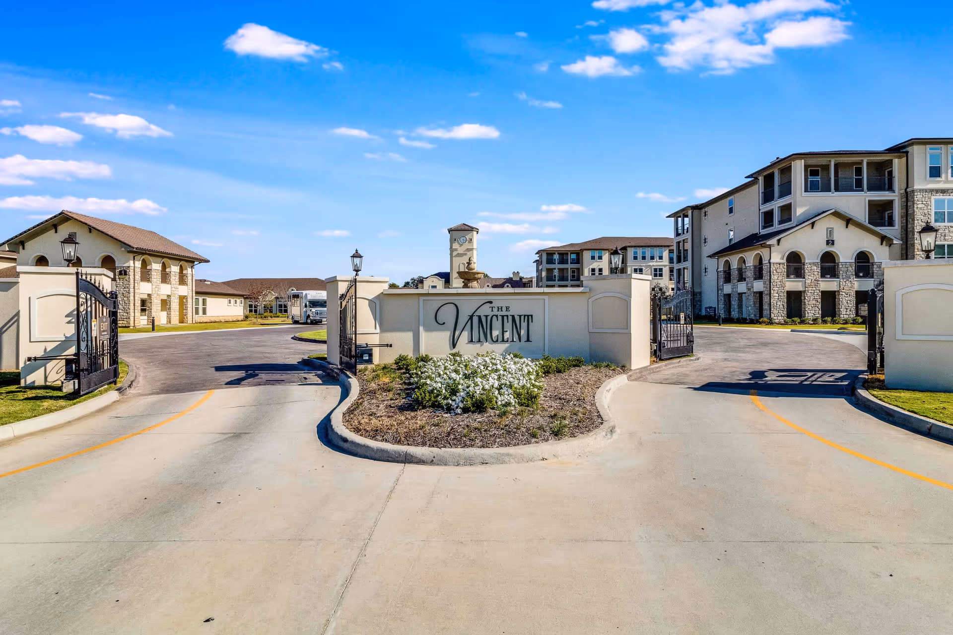 Gated entrance and driveway with a sign reading "The Vincent" and senior living buildings visible behind it.