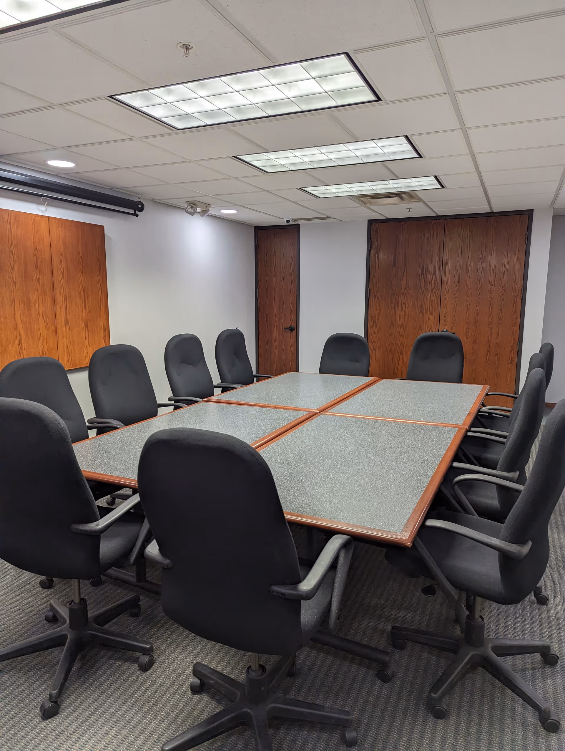 Unoccupied conference room in a senior home facility with a large modular table and chairs.