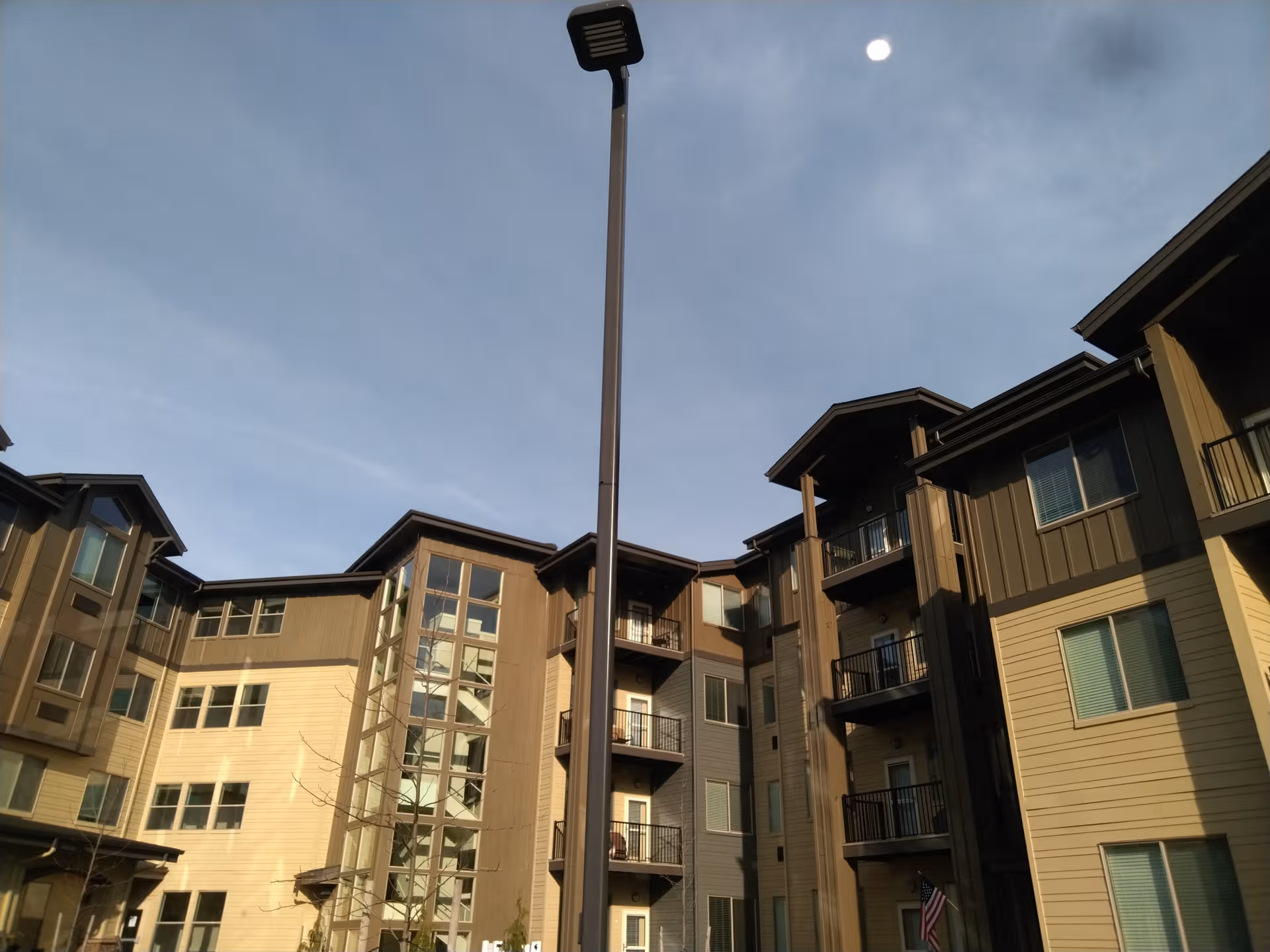 Exterior view of Bonaventure of Vancouver building with balconies and a streetlamp against blue sky.