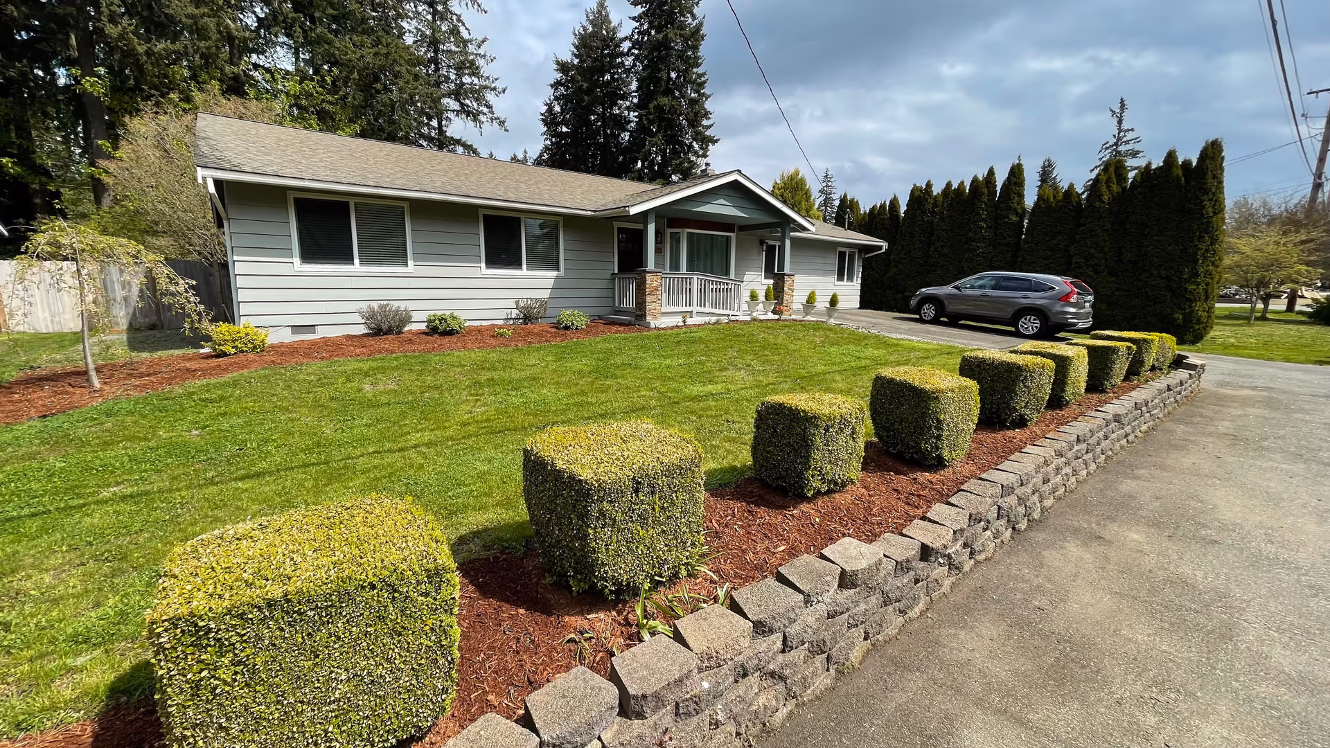 Front exterior of Abbey Road Care Home LLC, a single-story building with trimmed hedges and driveway.