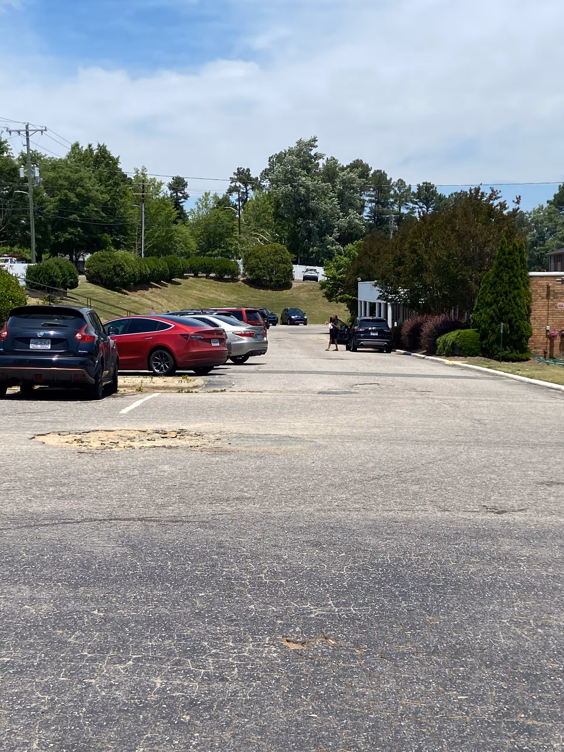 Parking lot in front of Durham Nursing & Rehabilitation Center with cars and trees.