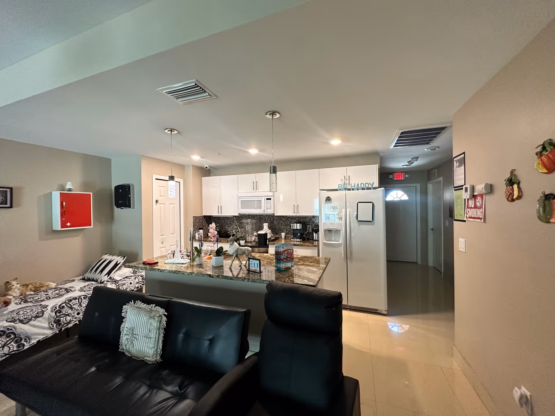 Open-concept living area in a senior facility featuring a kitchen island and sofa.