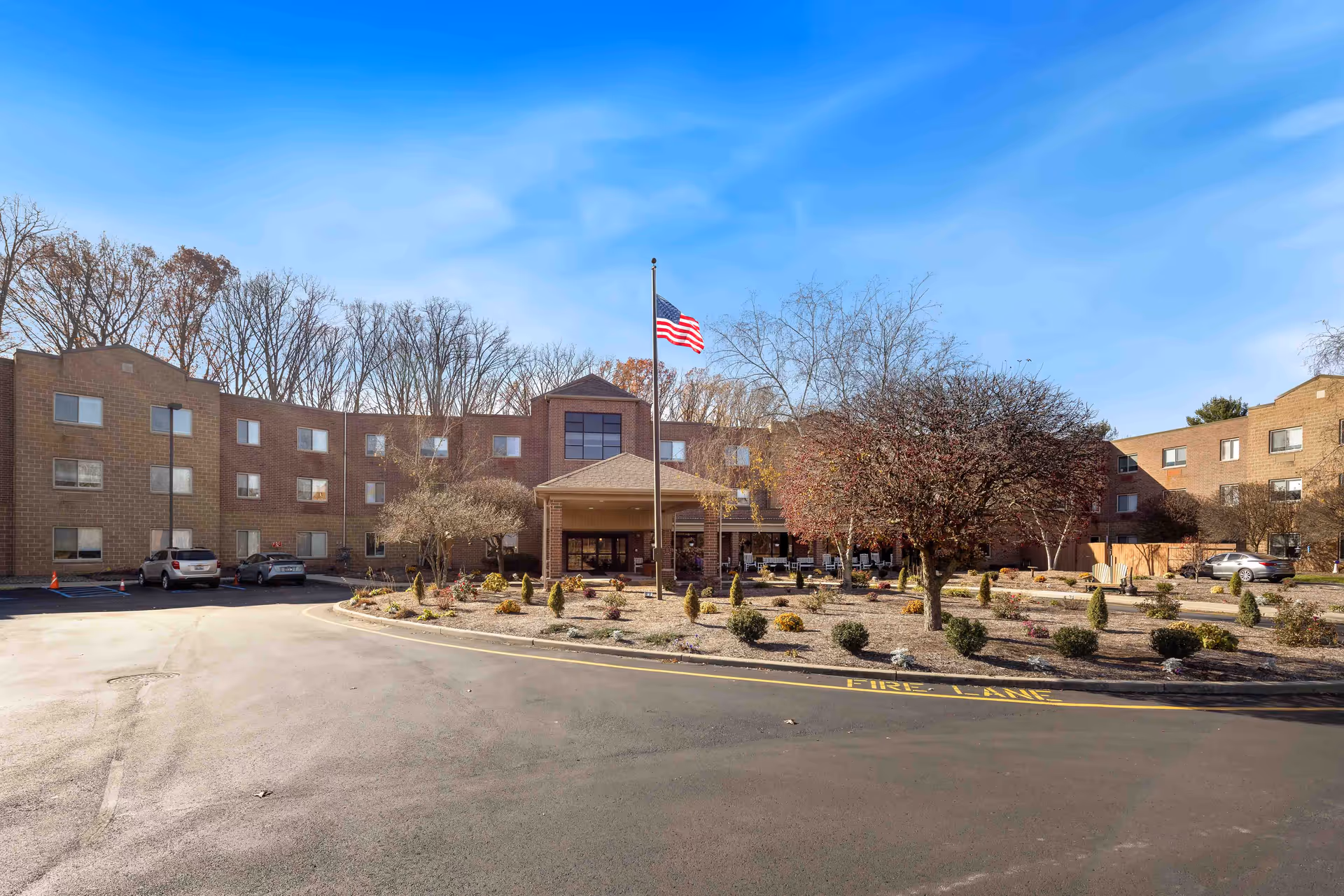 Exterior view of Whispering Oaks Hermitage, showing flagpole, entrance, and landscaped front.
