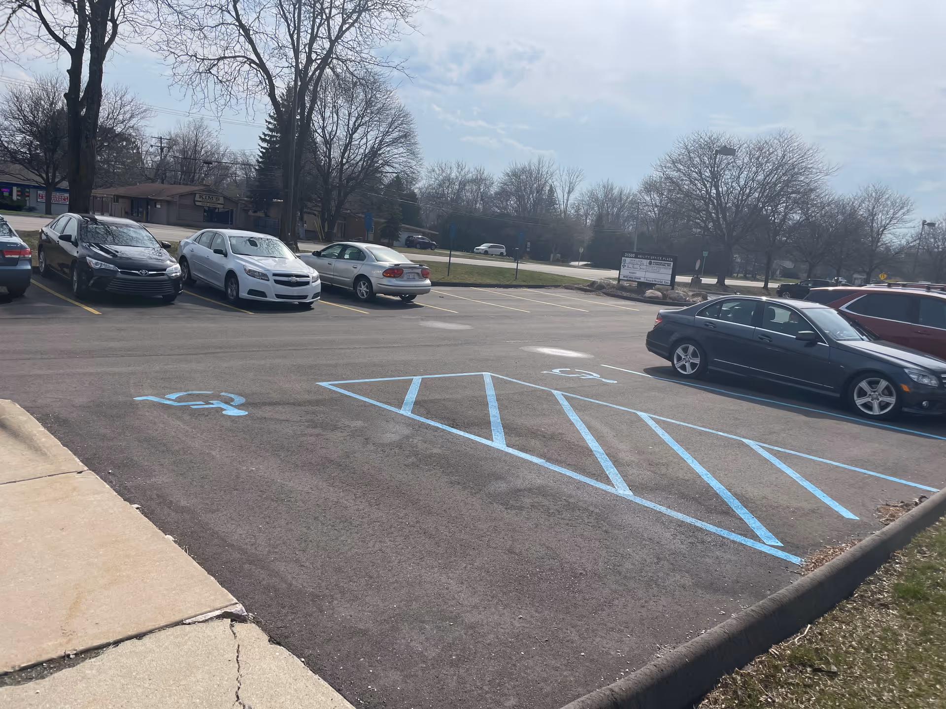 Parking lot in daylight with blue handicap markings outside VPS of MI PLLC facility.