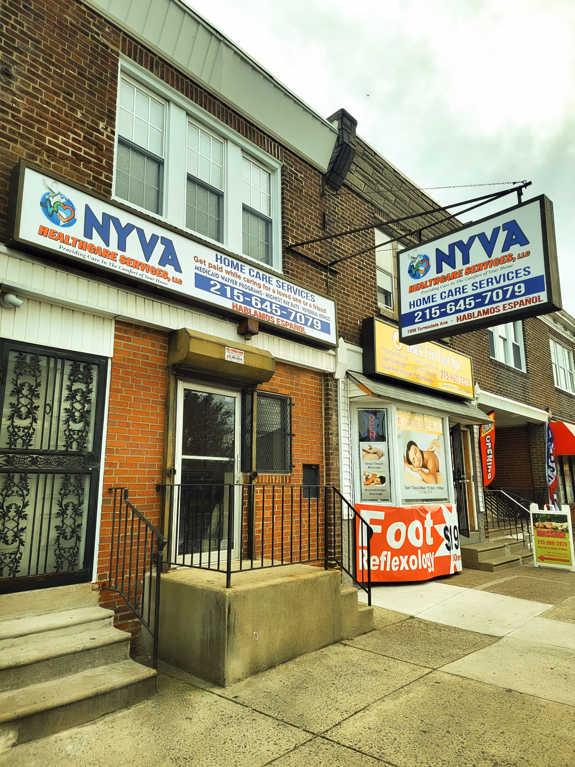 Brick storefronts with NYVA Healthcare Services signage and steps leading to entrances.
