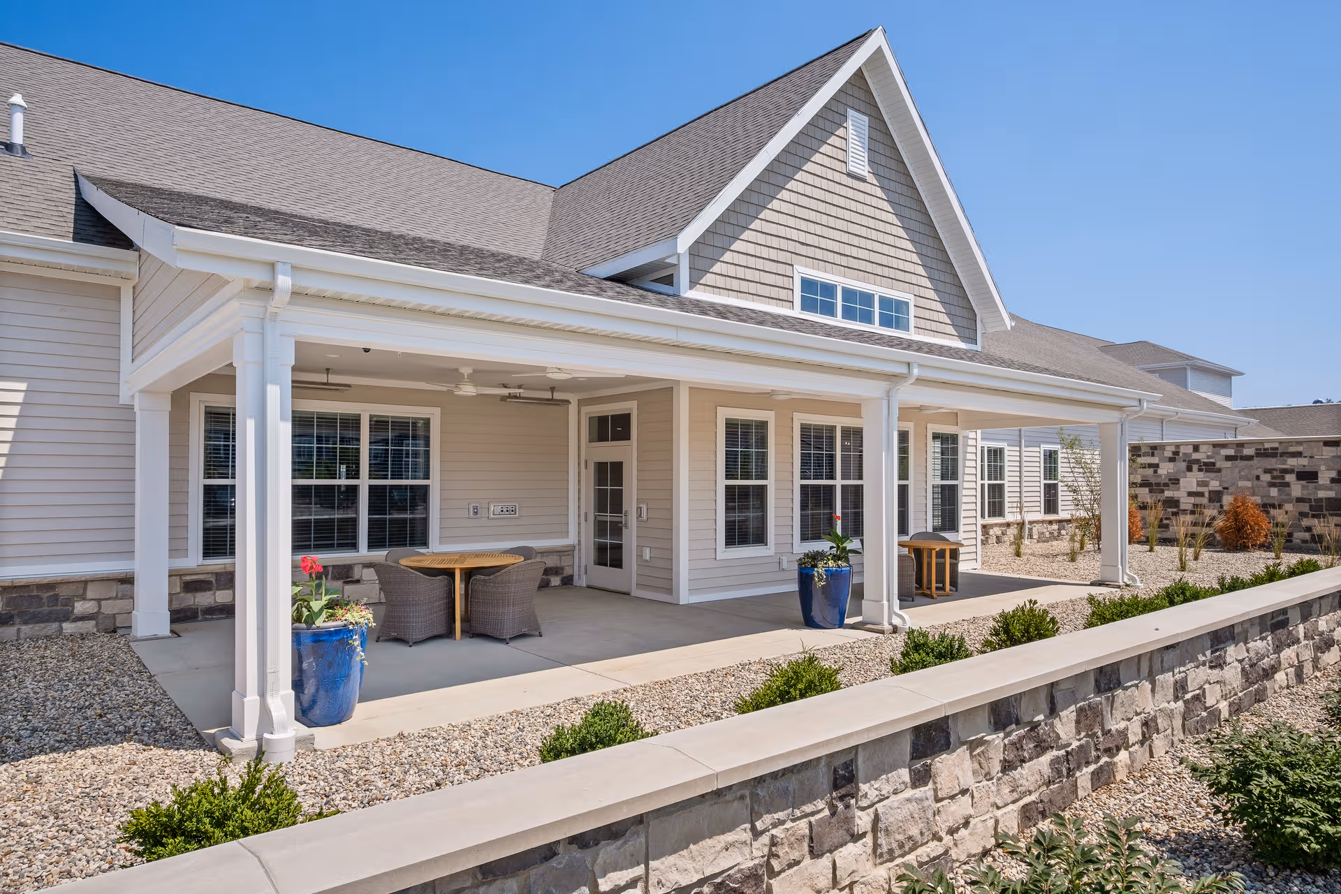 Exterior view of Quincy Place Senior Living with a covered front porch and patio seating.