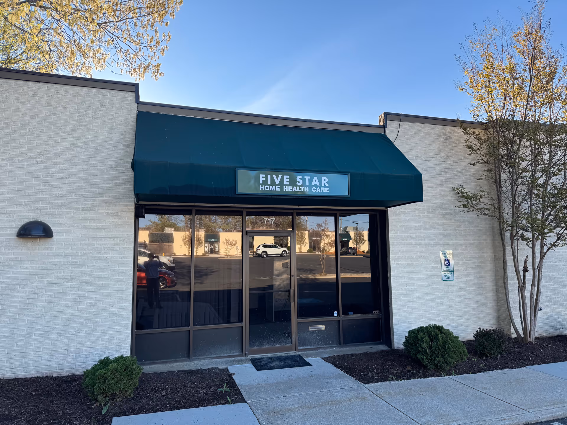 Front entrance of Five Star Home Health Care with a green awning and glass doors.