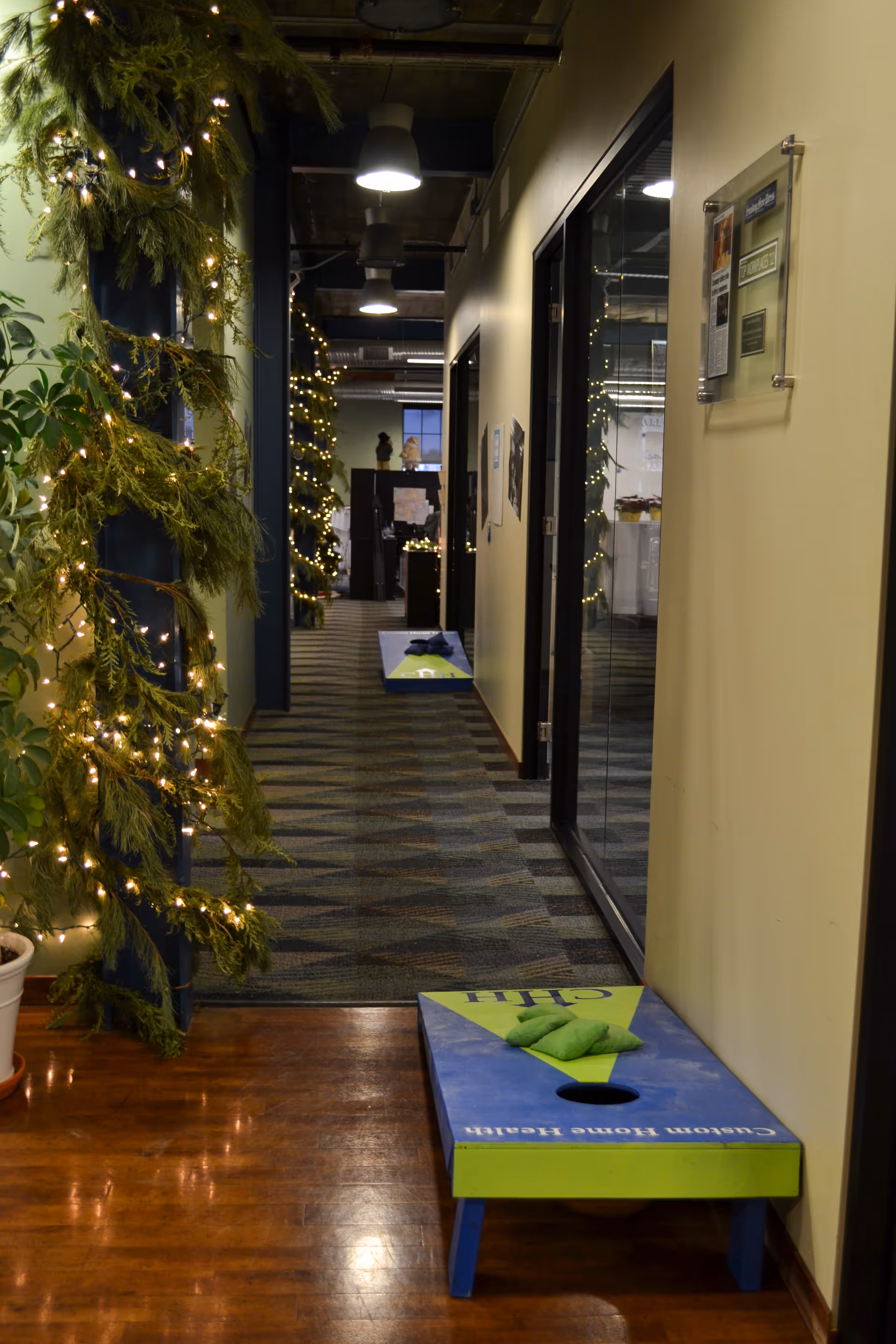Indoor hallway at Custom Home Health, Inc., decorated with string lights and a bench.