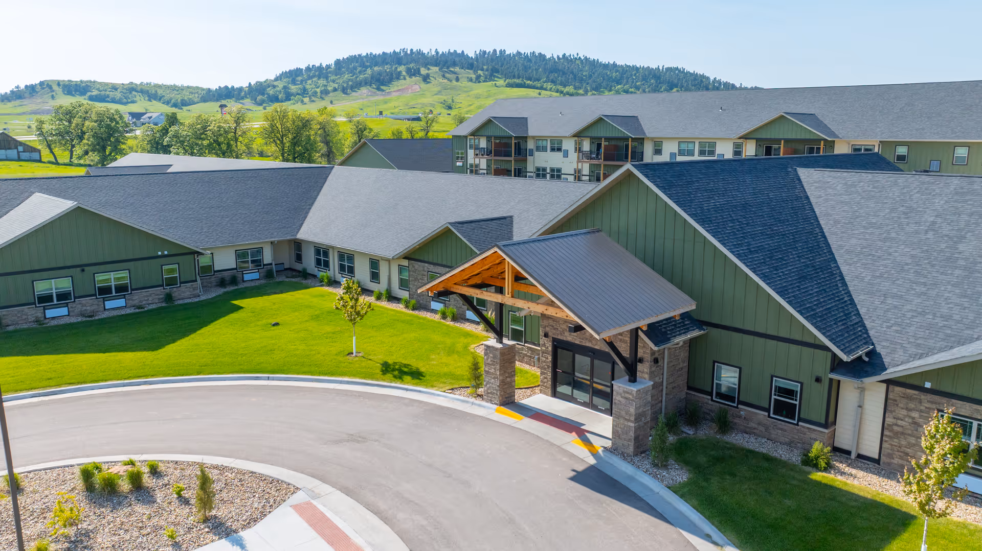 Exterior view of Peaceful Pines Senior Living at Spearfish with a green entrance canopy.
