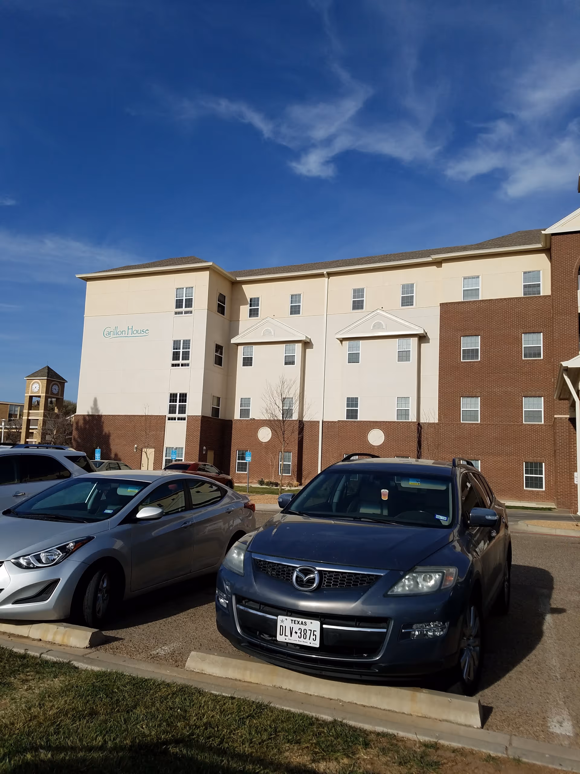 Exterior view of a Carillon senior living building with parked cars