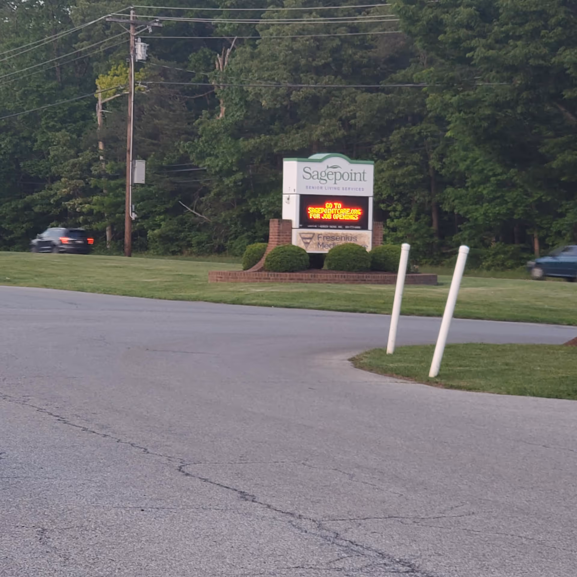 Sagepoint Memory Care sign on a grassy median with trees in background.