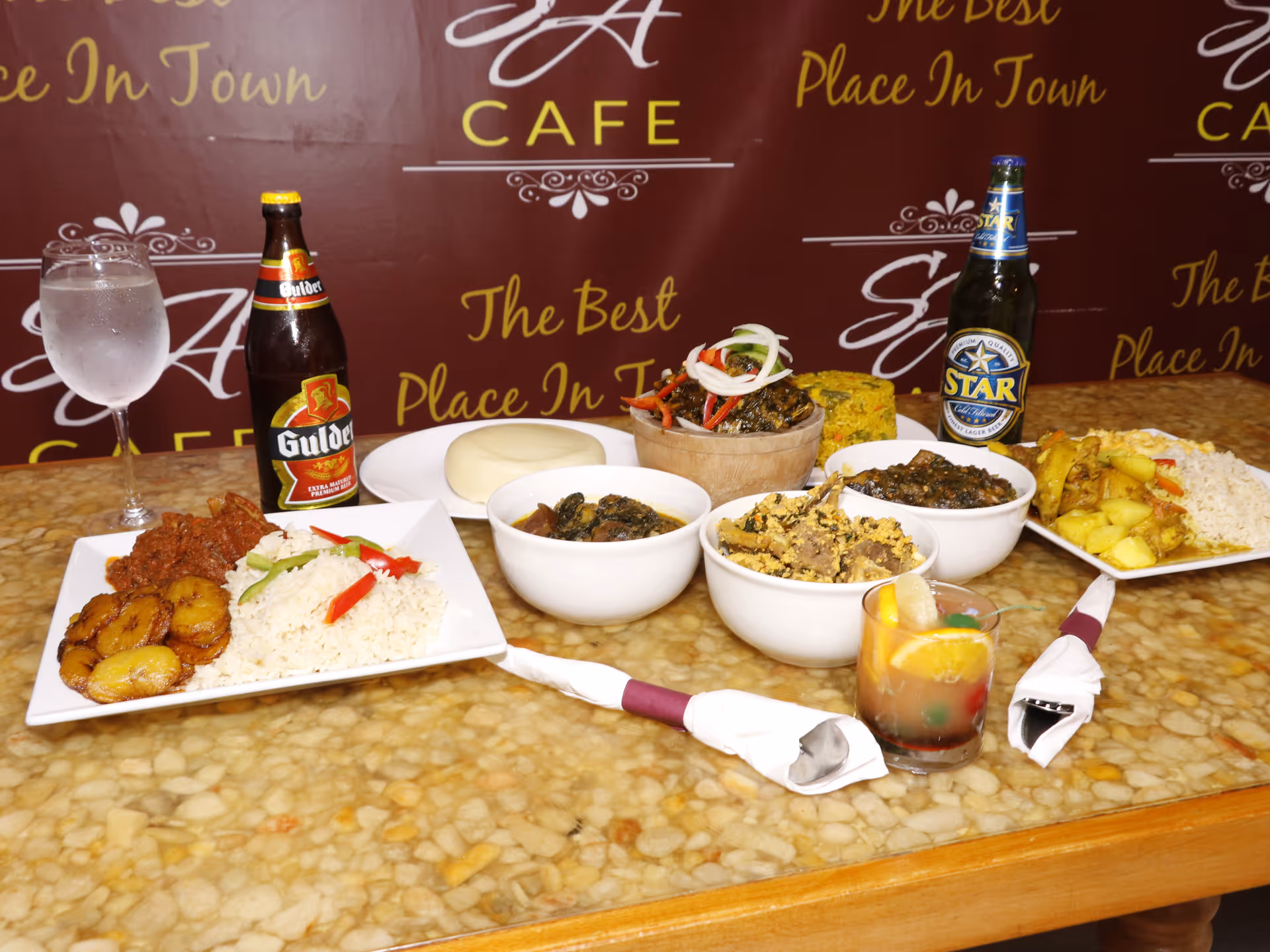 Table loaded with assorted dishes and drinks in a cafe-style dining setup.