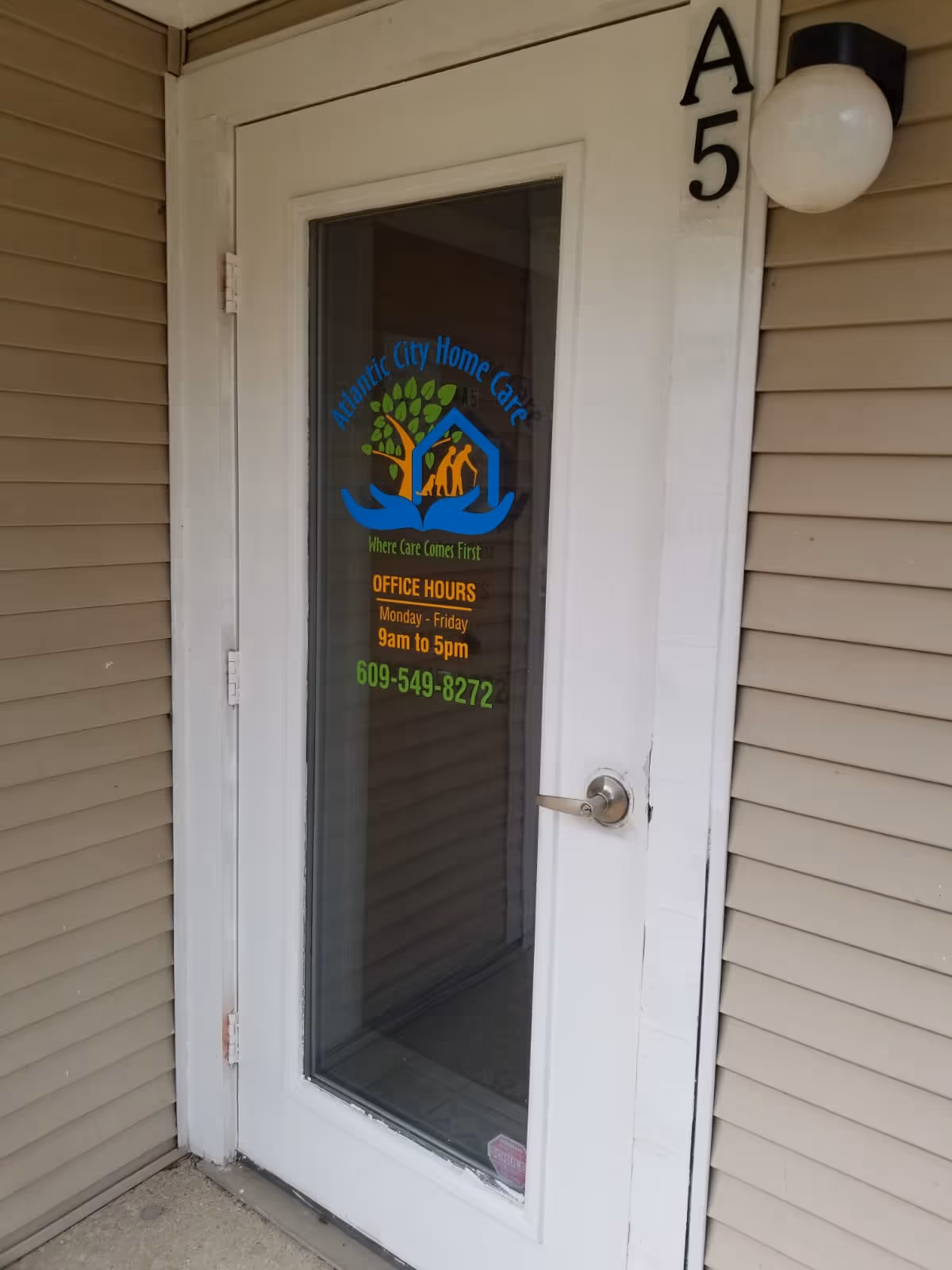 White exterior door with Atlantic City Home Care logo on glass panel.