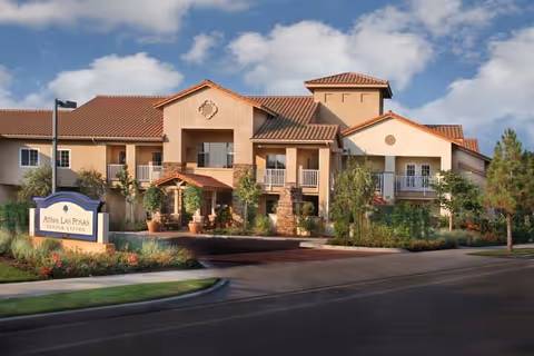 Exterior view of Atria Las Posas senior living facility with landscaped entrance and sign.