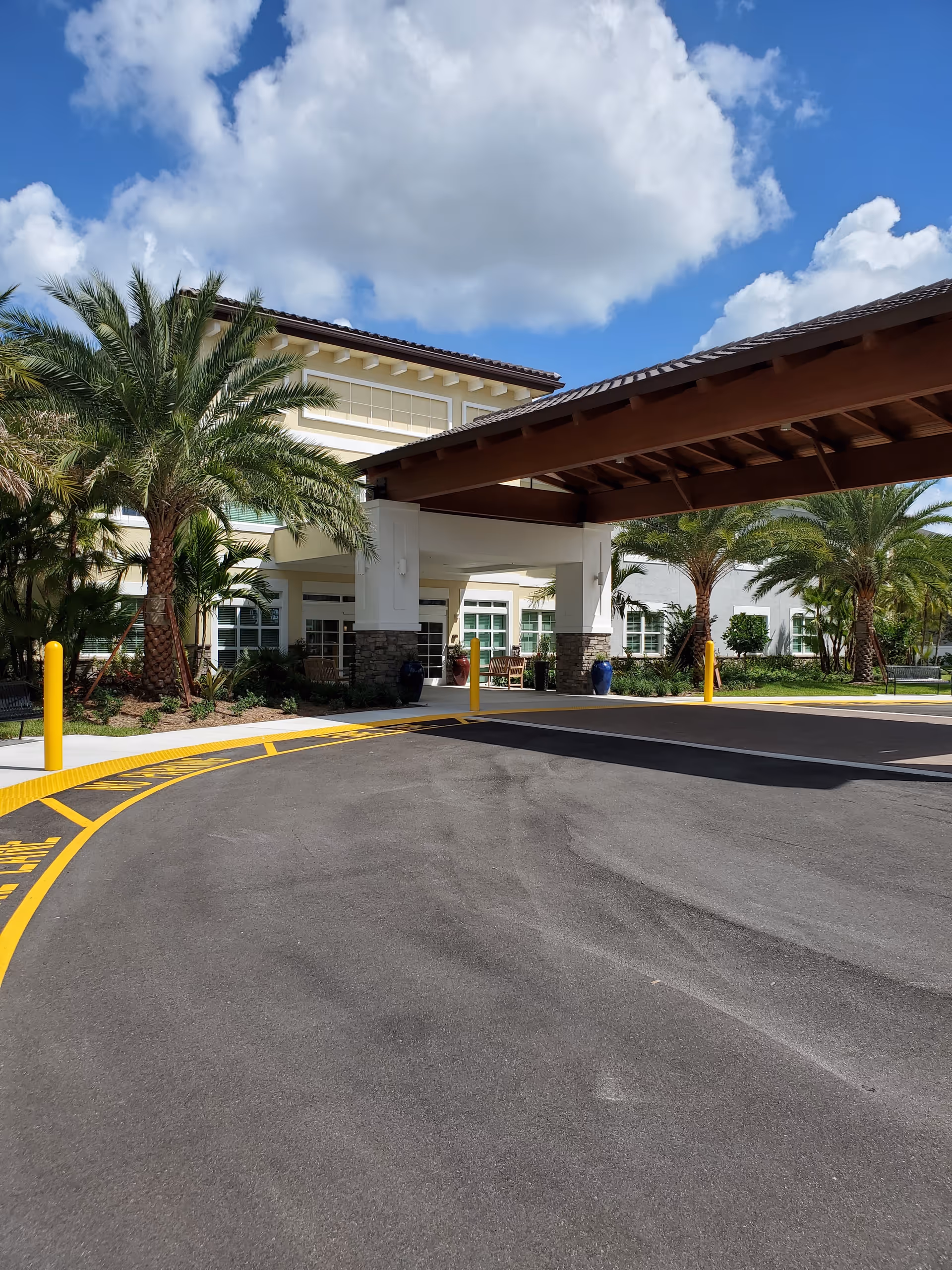 Exterior view of YOURLife Coconut Creek entrance with palm trees.