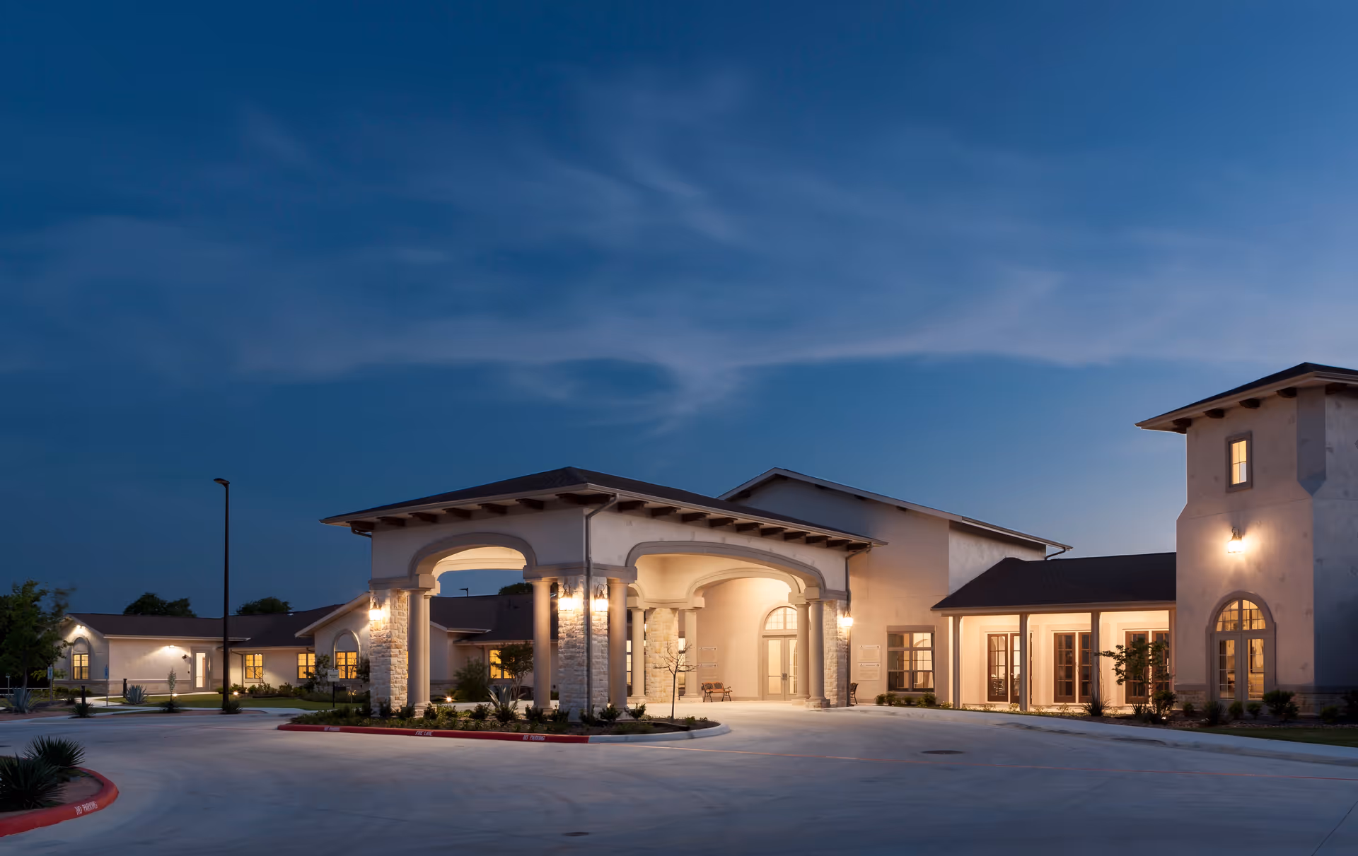 Evening exterior view of Franklin Park Boerne facility with illuminated porte-cochère and entryway