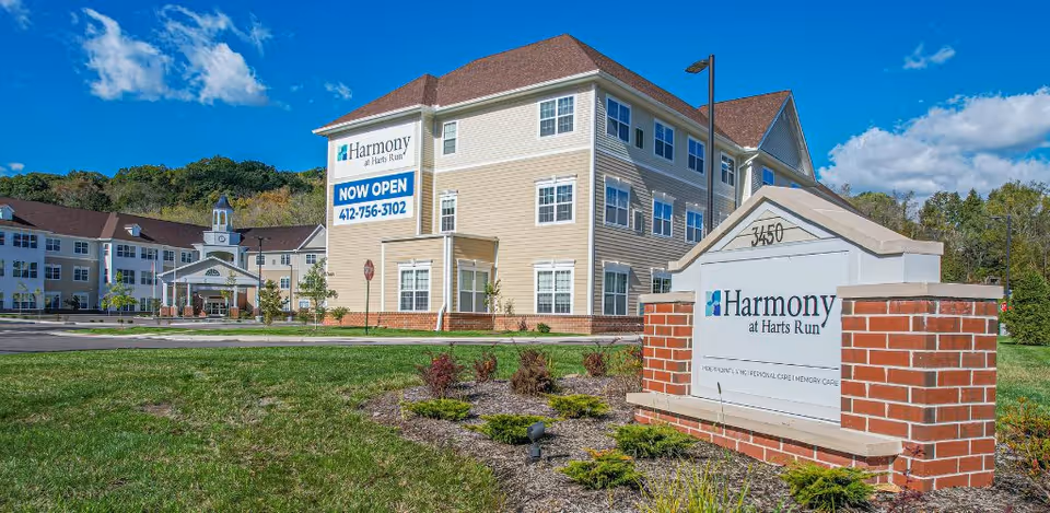 Exterior view of Harmony at Harts Run building with sign and landscaped front yard