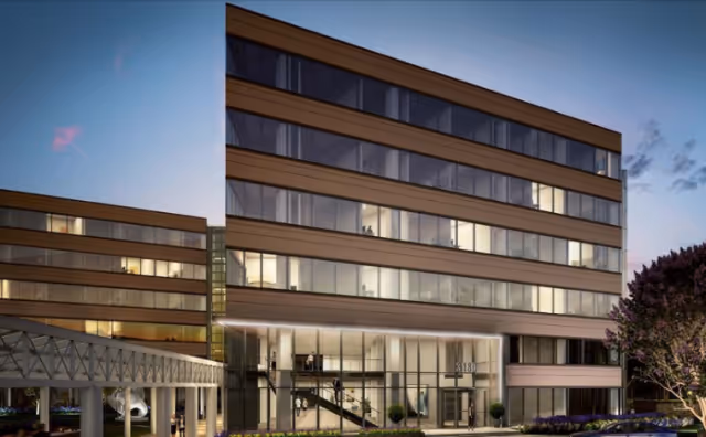 Capital Caring Health Headquarters exterior: a modern glass-front building at dusk.