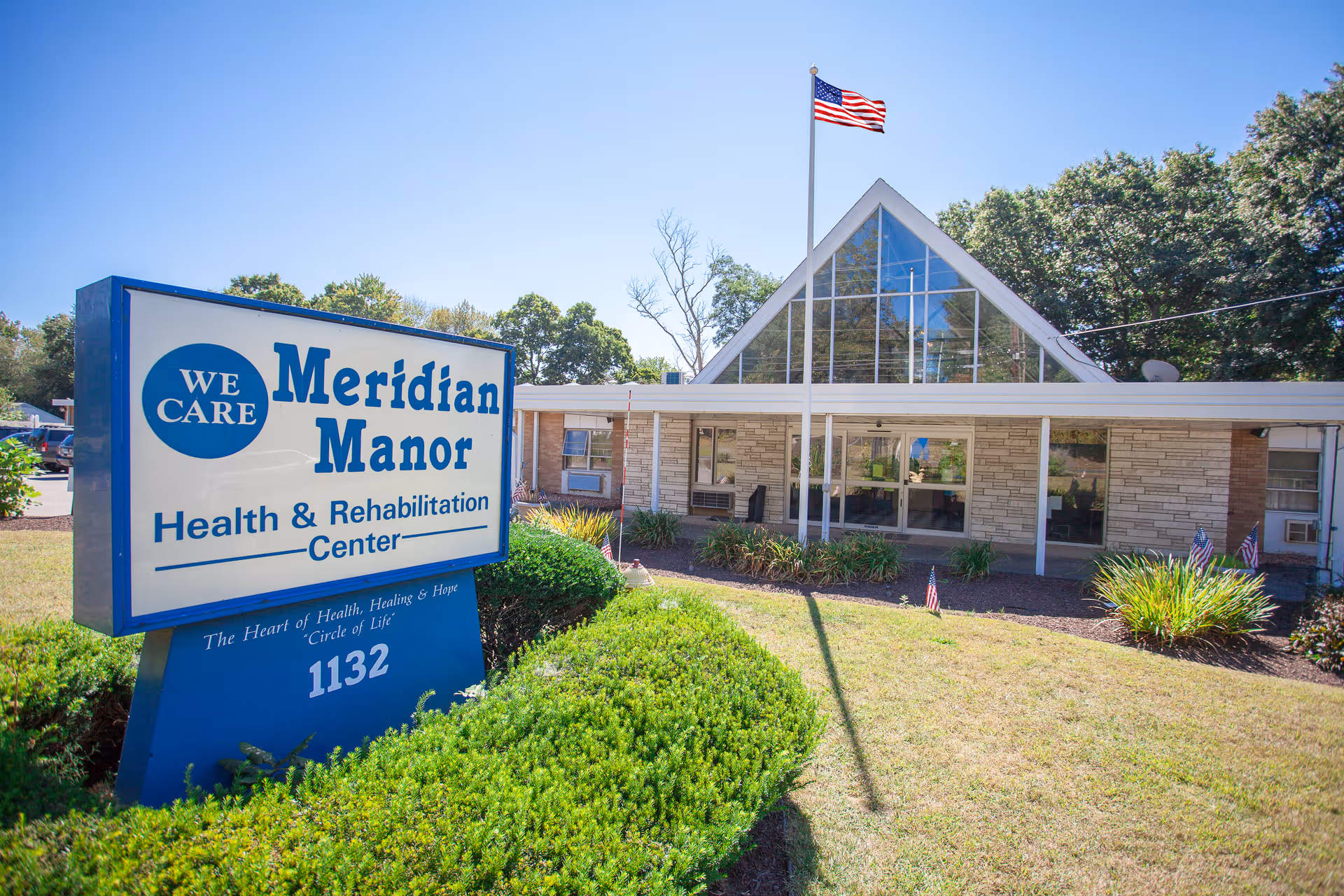 Exterior view of Meridian Manor Health and Rehabilitation Center with a large sign.