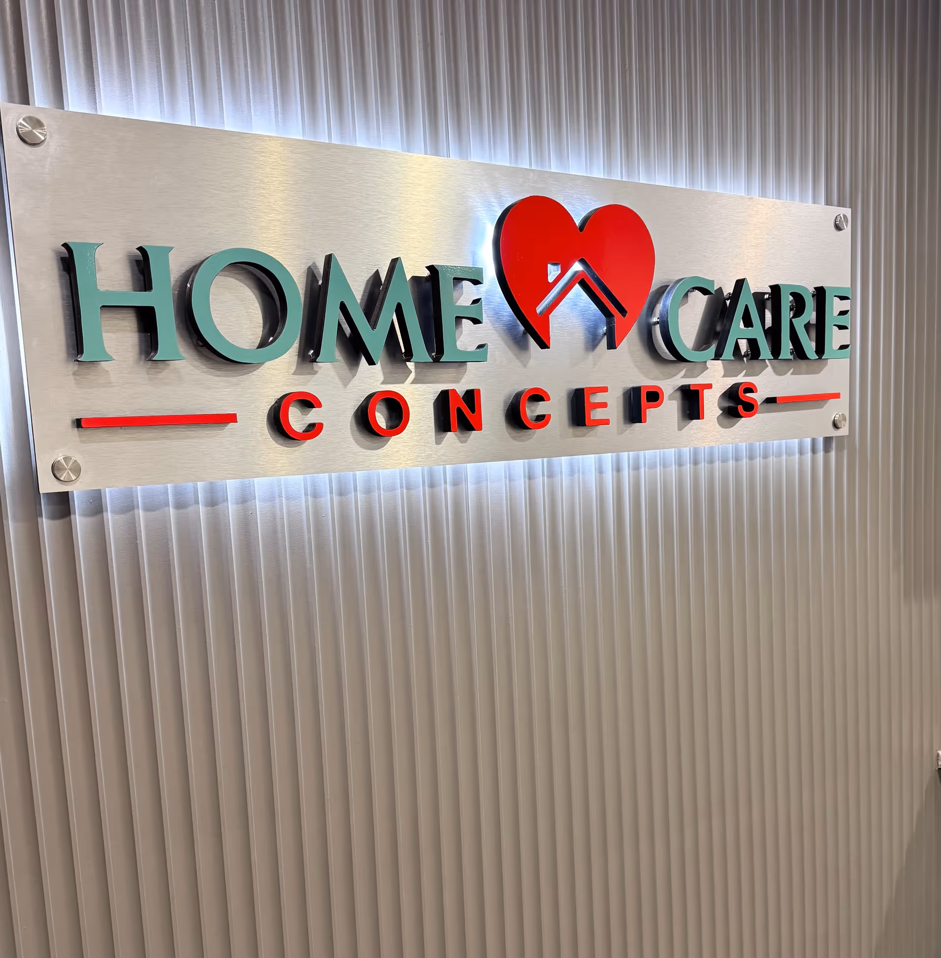 Interior wall with a metal sign reading Home Care Concepts and a red heart logo.