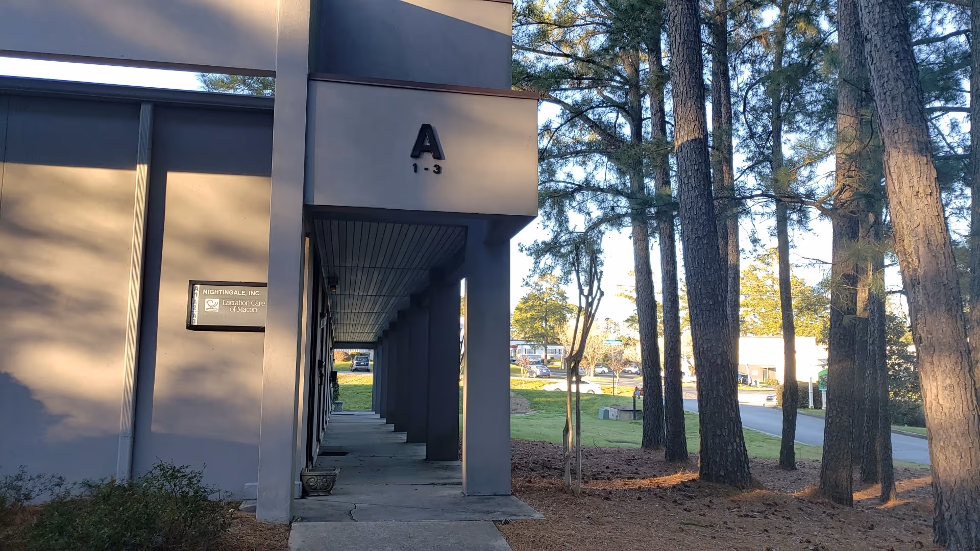 Exterior view of Nightingale Home Care, Inc. entrance with shaded walkway and trees.