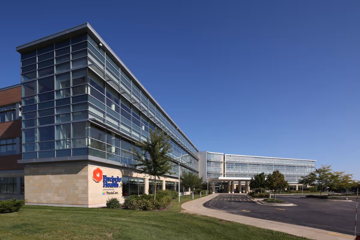 Glass-fronted Encircle Health facility exterior under a clear blue sky.