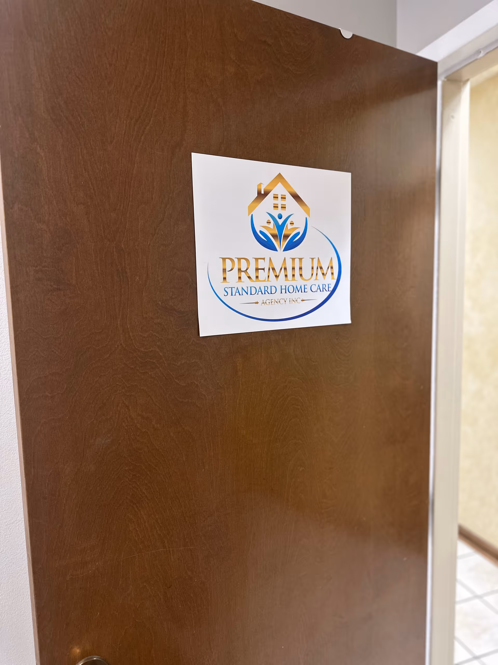 Wooden door in a hallway with Premium Standard Home Care logo.