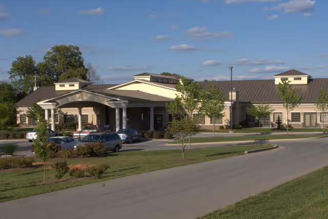 Exterior view of Hospice of Southern Kentucky facility with covered entrance and parked cars.