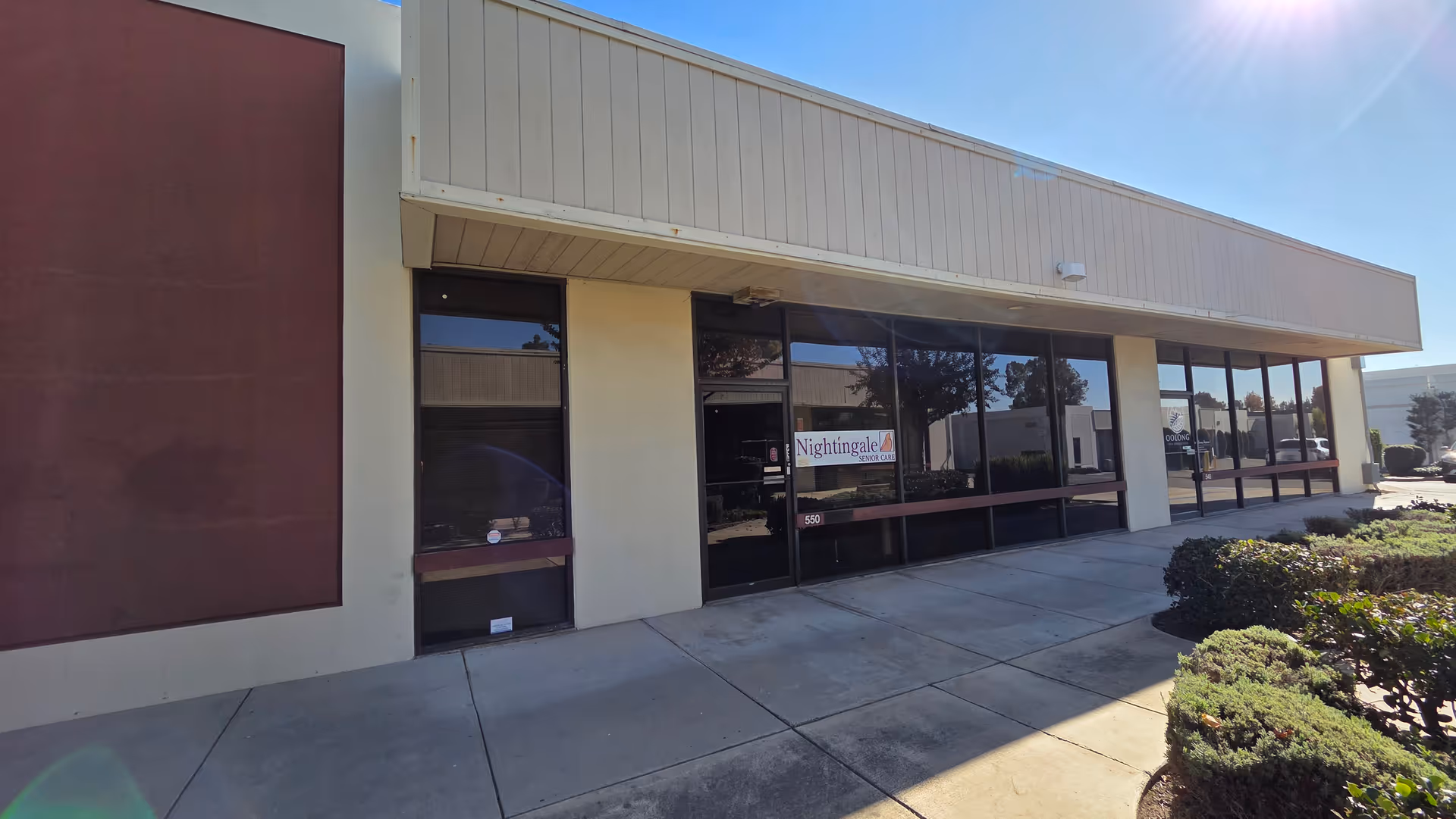 Exterior of Nightingale Senior Care facility with large glass windows and a sidewalk.