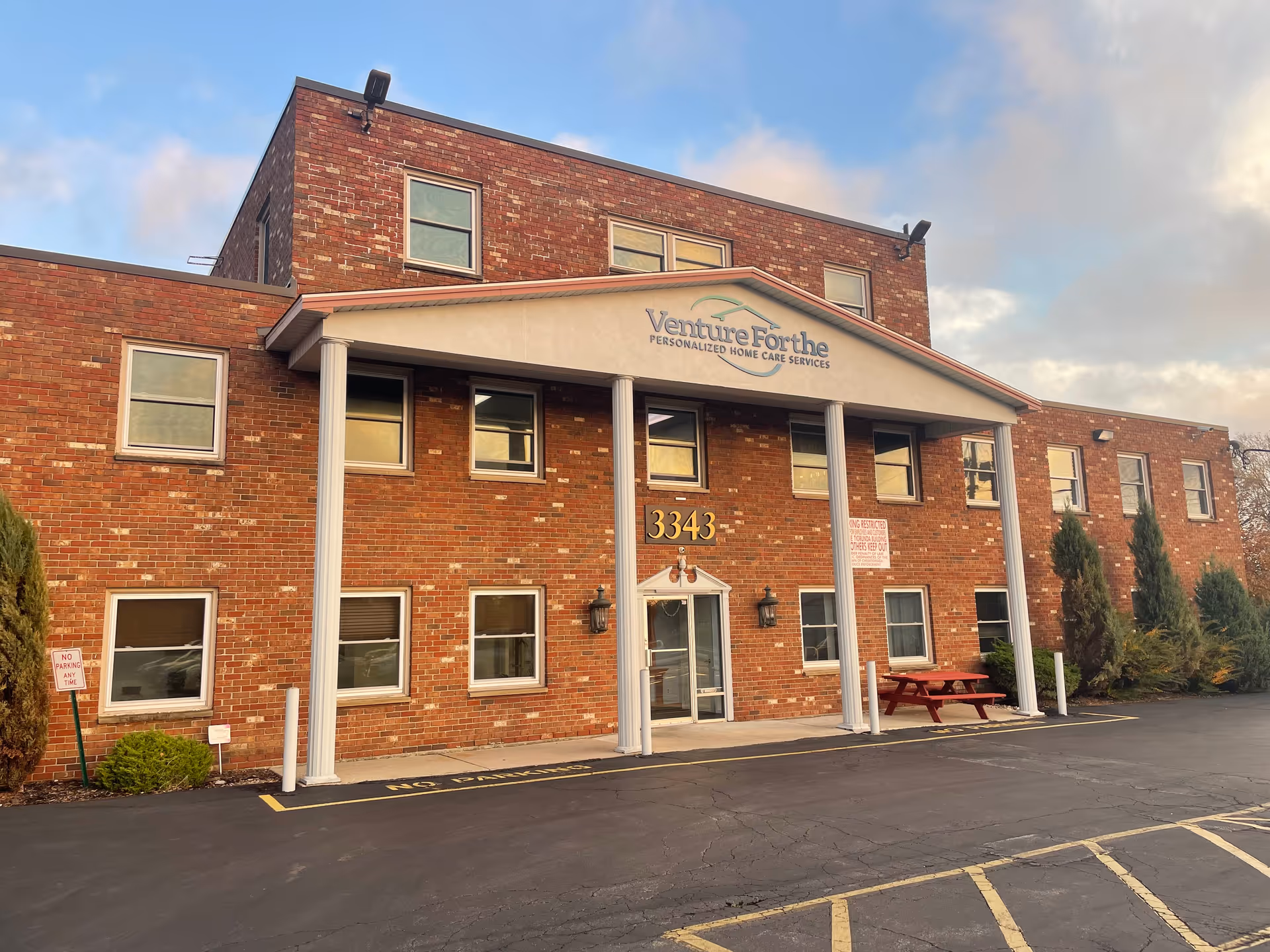 Front exterior of Venture Forthe senior care facility with brick facade, columns, and entrance sign.