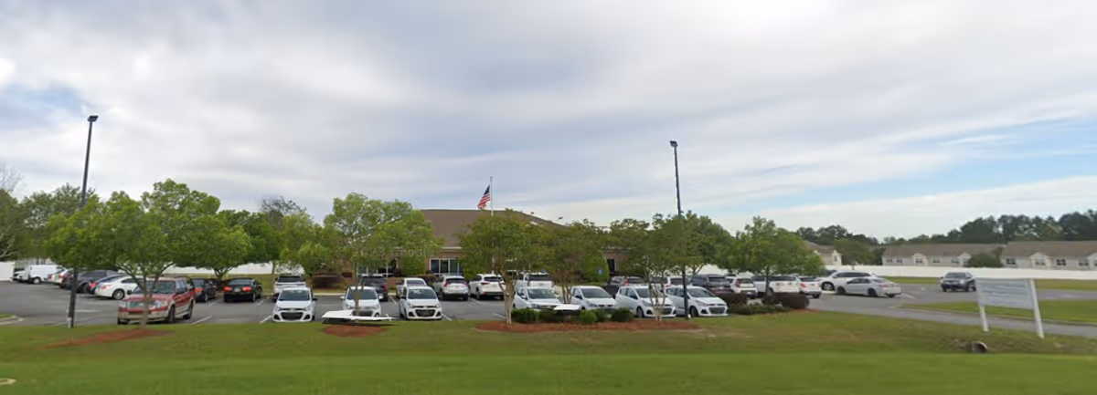 Front exterior of Colquitt Regional Hospice with cars parked in the lot.
