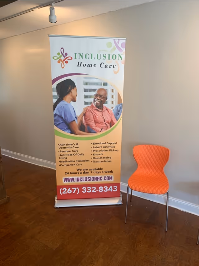 Indoor lobby with an Inclusion Home Care banner and an orange quilted chair.