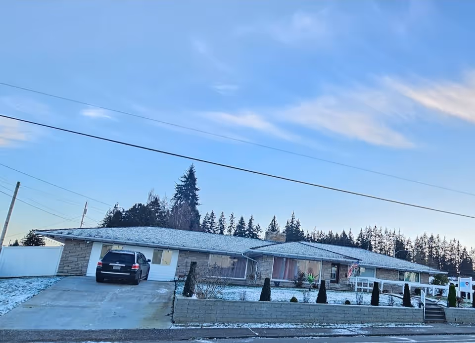 Front view of a single-story care facility exterior with a driveway.