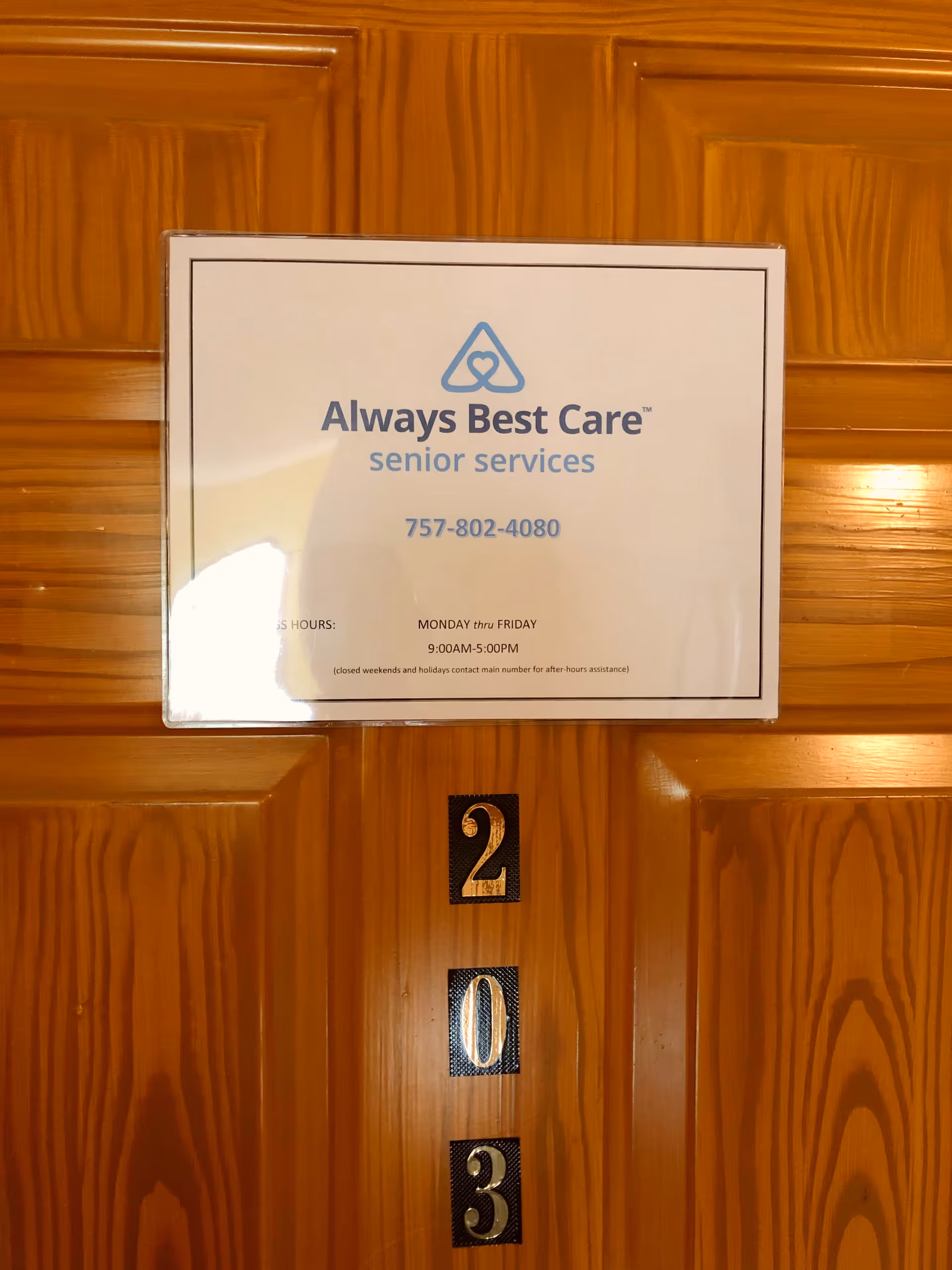 Always Best Care senior services sign with phone number on a wooden door.