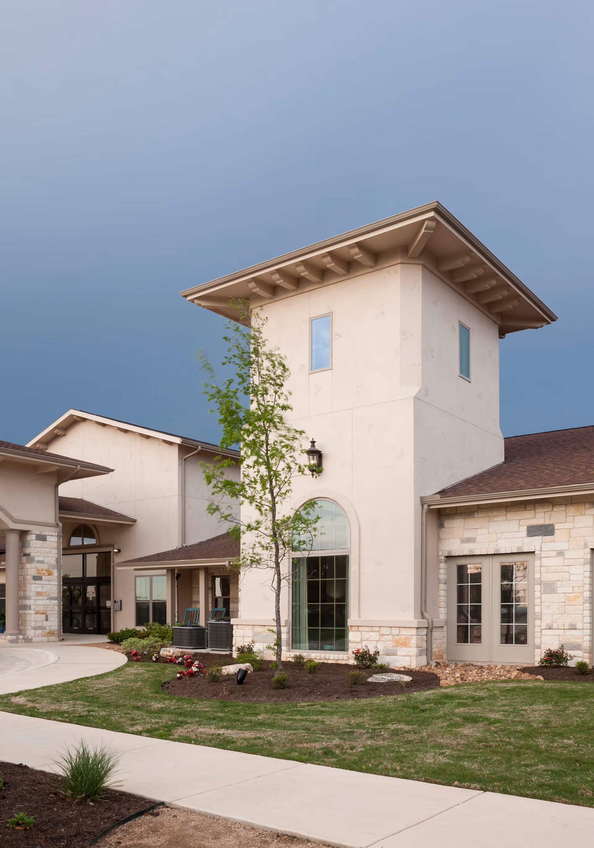 Exterior view of Volante Senior Living of Round Rock with entrance, tower, and grounds.