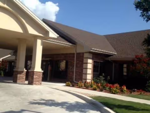 Front entrance of The Rio at Mission Trails, with beige columns and landscaping.