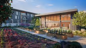 Landscaped courtyard with raised garden beds, benches, and a modern glass-front building under a blue sky.