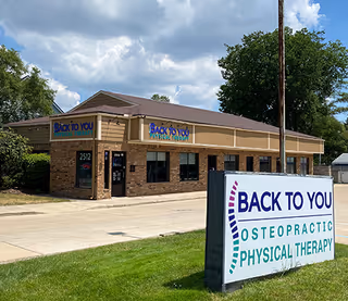 Exterior brick clinic building with Back to You Osteopathic Physical Therapy signage.