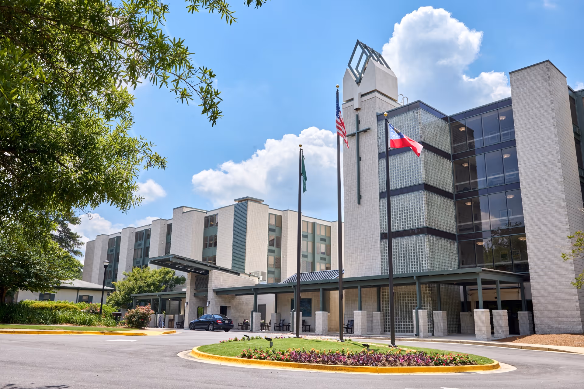 Christian City Assisted Living Center exterior with flags and glass entrance.