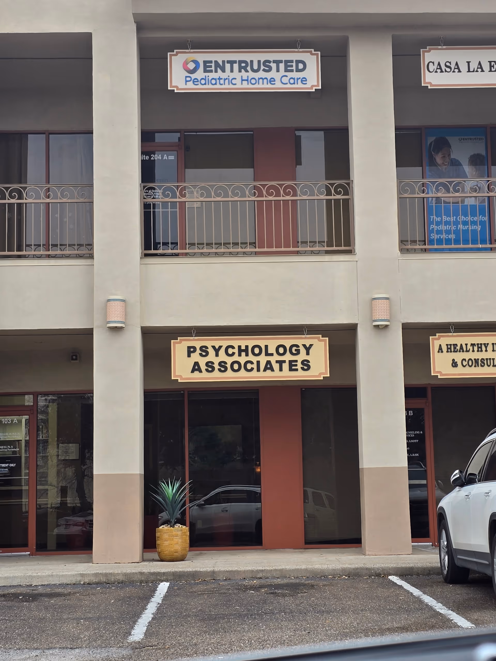 Two-story storefront complex with Entrusted Pediatric Home Care and Psychology Associates signage.