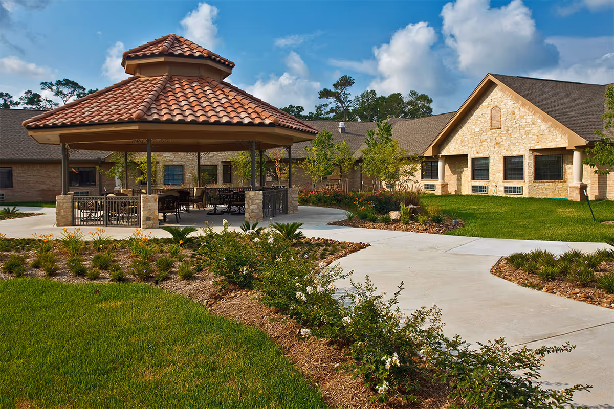 Exterior view of Villa Toscana at Cypress Woods featuring a shaded gazebo and landscaped walkways.