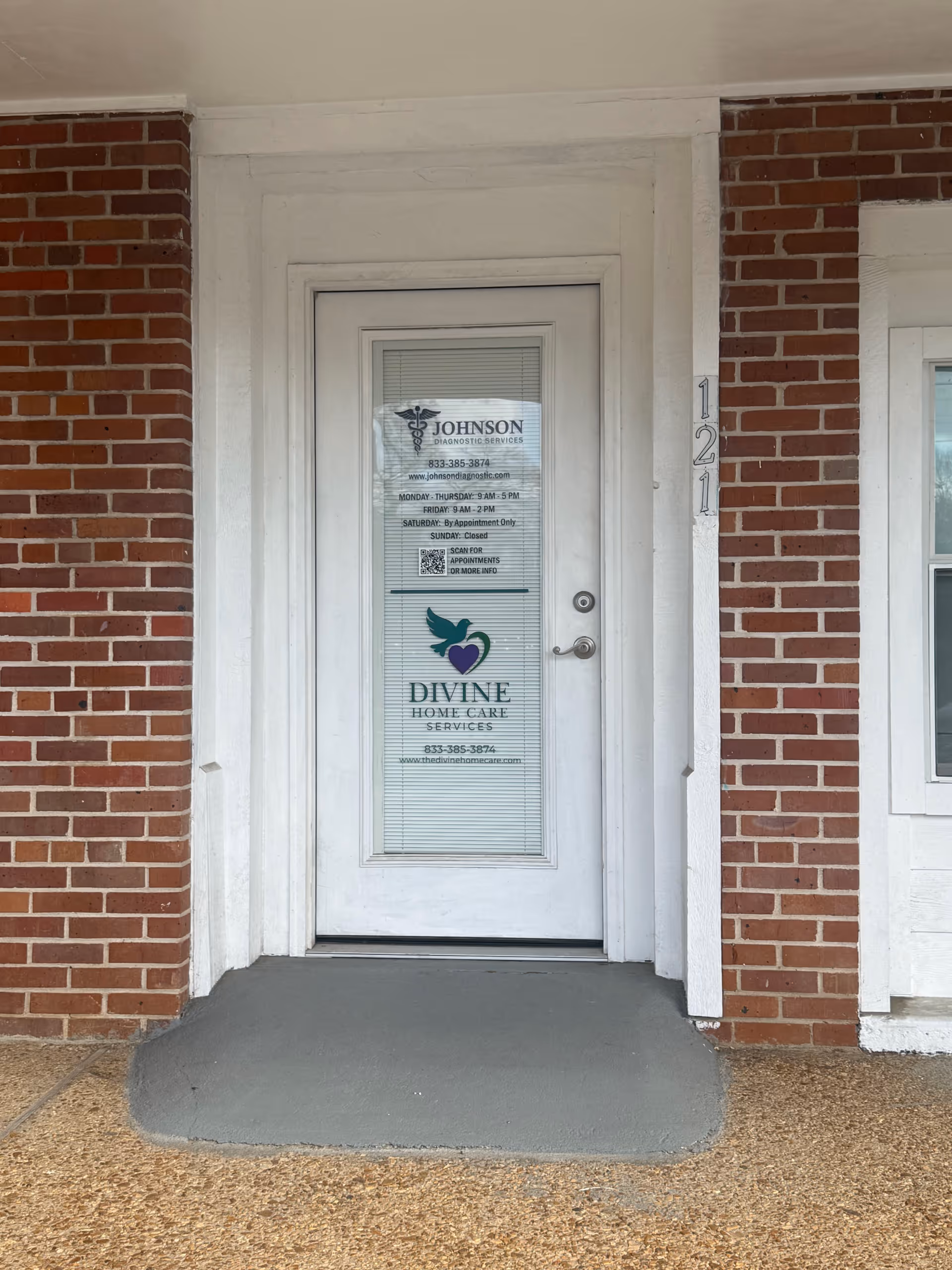 White entrance door with signage for Divine Home Care Services on a brick exterior.
