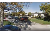 Front exterior view of Parkview Care And Rehabilitation Center with parked cars and trees.