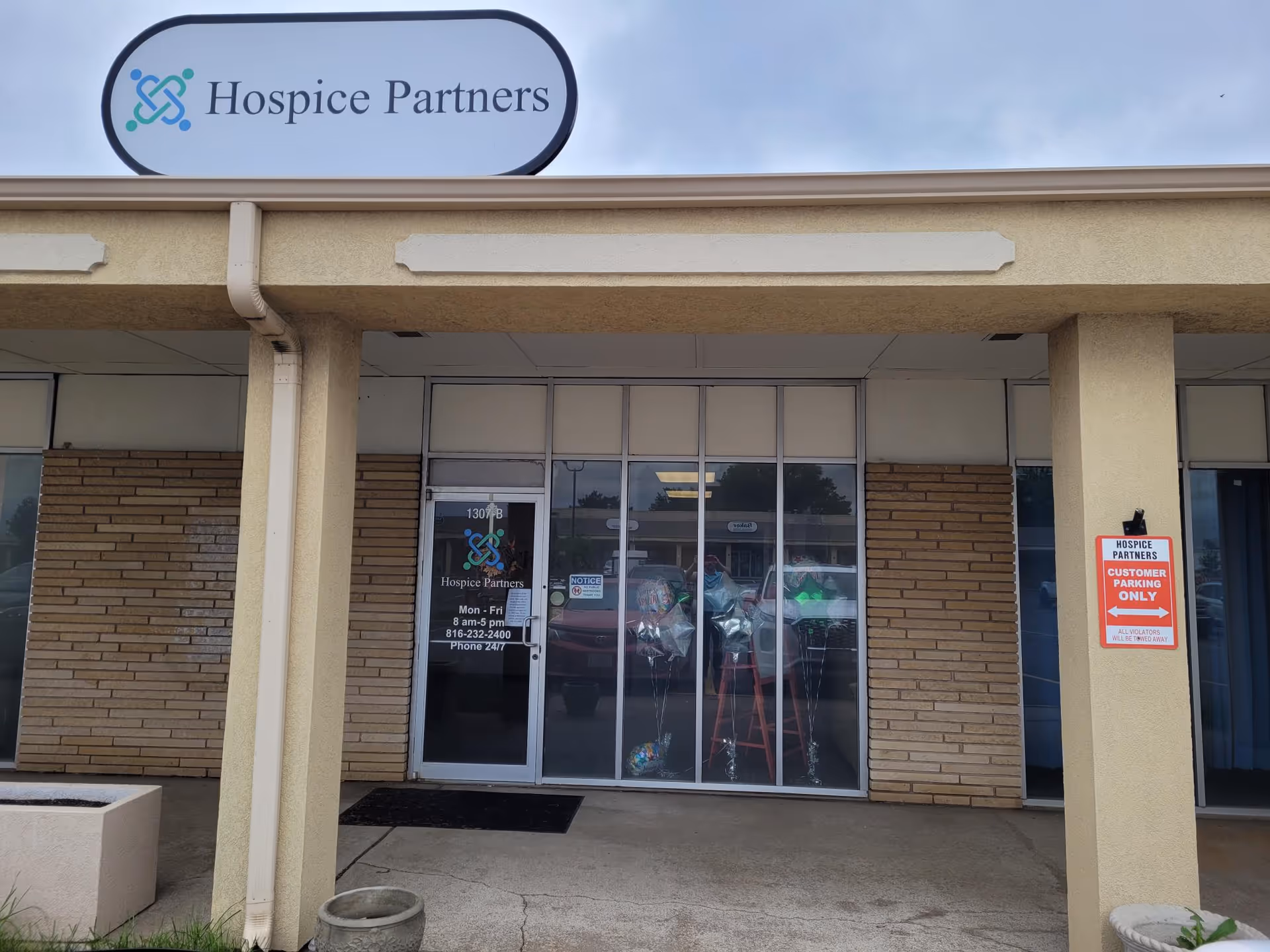 Exterior of a hospice facility with glass doors and a prominent sign.