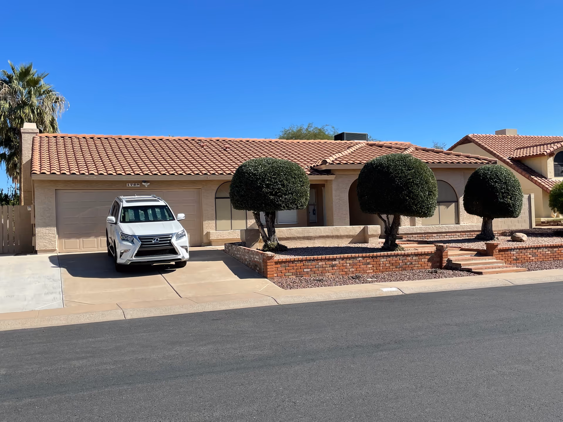 Front exterior of a single-story facility with a white SUV in the driveway.