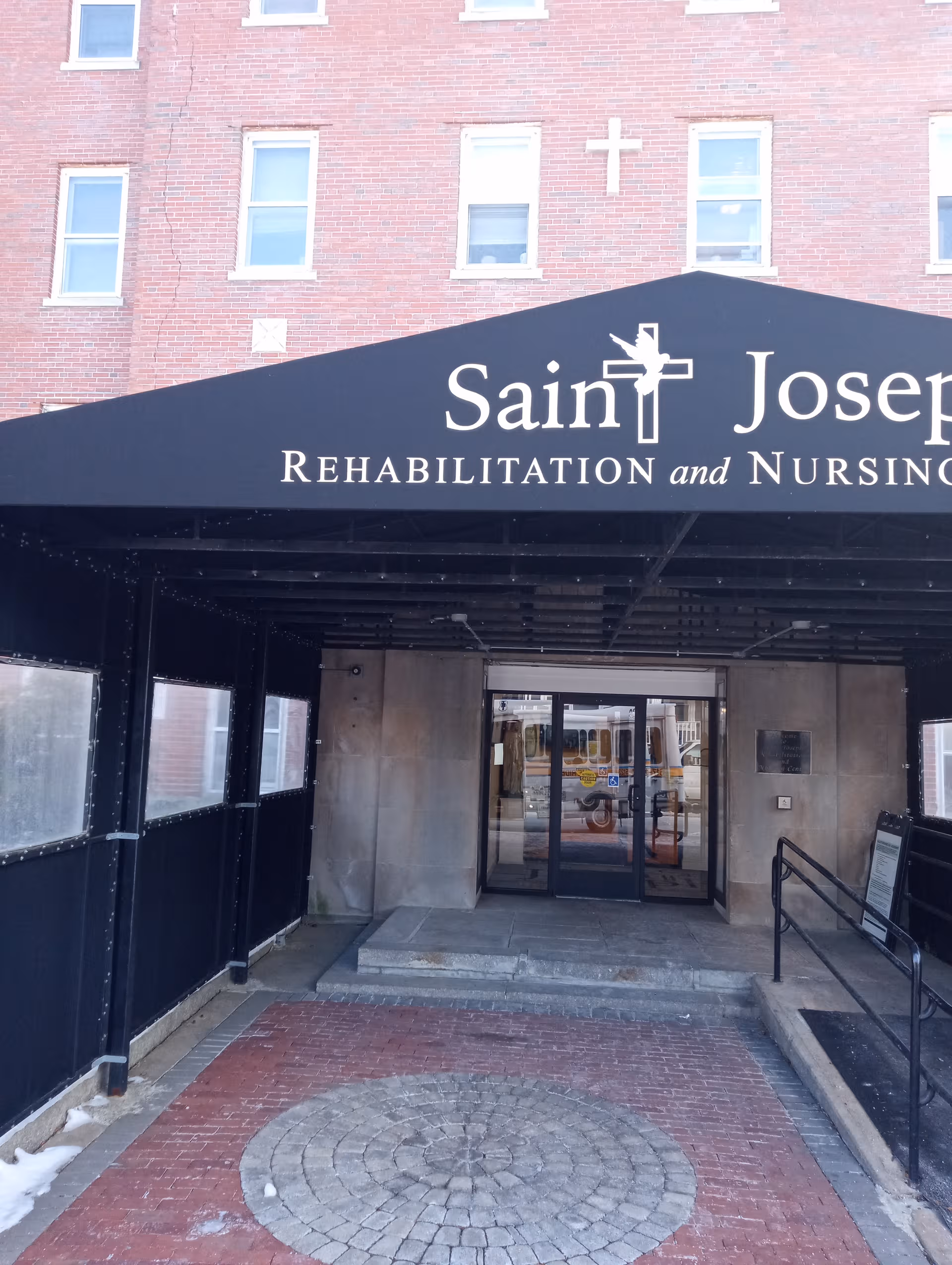 Exterior brick entrance of Saint Joseph Rehabilitation and Nursing Center with a large canopy.