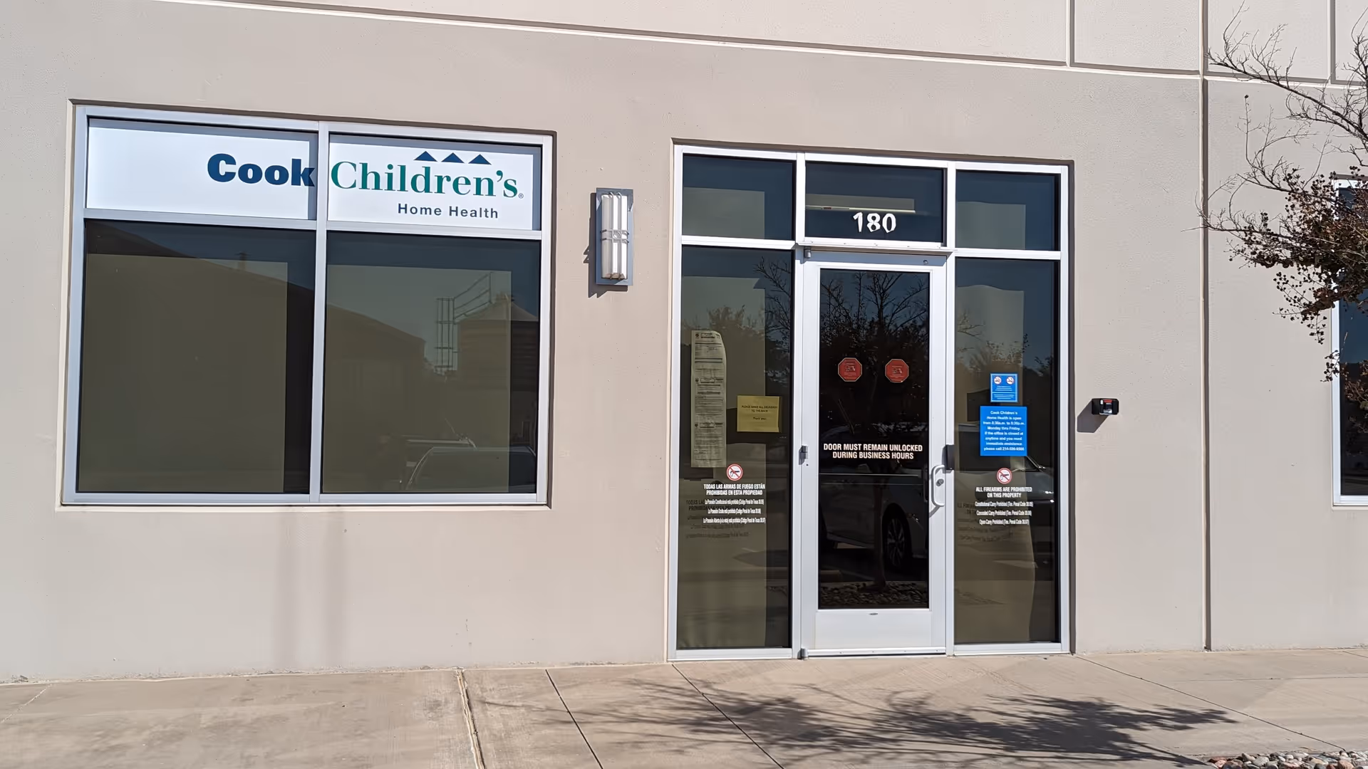 Front view of a beige building with glass door entrance and Cook Children's Home Health sign.